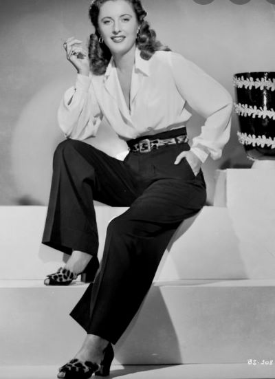 barbara stanwyck in black pants seated